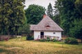 charming country cottage with a shingle roof and a porch and a small garden. Zwierzyniec, Poland