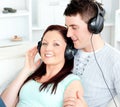 Charming couple listening to music with headphones