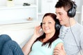 Charming couple listening to music with headphones