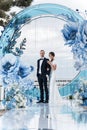 Charming couple in love in a chic banquet room in the open air against the backdrop of the sea on a gala wedding day