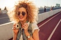 Charming curly blonde listen to music. Young woman with big headphones. outdoors portrait of a trendy girl Royalty Free Stock Photo