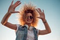 Charming curly blonde music lover gives fives. Young woman with big headphones. Royalty Free Stock Photo