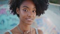 Charming curly girl smiling posing at skate park close up. African teenager Royalty Free Stock Photo