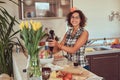 Charming curly Hispanic girl cooking in her kitchen. Royalty Free Stock Photo