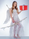 Charming curly woman in white dress and wings - angel cupid girl. arrow and wings. Angel girl with blonde hair. Real Royalty Free Stock Photo