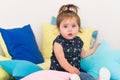 Charming cute two year old girl sitting on pillow Royalty Free Stock Photo