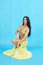 Charming dancer performs oriental belly dance on a blue background.