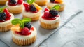 A charming display of mini cheesecakes topped with assorted fruit compotes and mint leaves Royalty Free Stock Photo