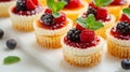 A charming display of mini cheesecakes topped with assorted fruit compotes and mint leaves Royalty Free Stock Photo
