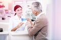 Charming druggist presenting pills to a buyer