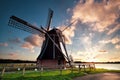 Charming Dutch windmill by lake at sunset