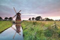 Charming Dutch windmill by river at sunrise