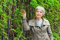 Charming elderly woman senior in park with foliage