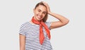 Charming Euroopean young woman wearing casual t-shirt, red scarf on the neck, smiling braodly and looking to the camera, isolated Royalty Free Stock Photo