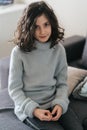 Charming European girl of 8 years posing sitting on the sofa.