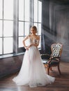 Charming excellent lady became bride, girl with blond gathered hair tries on wedding chic white luxurious light dress in Royalty Free Stock Photo