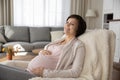 Charming expectant mother relax in comfy chair at living room Royalty Free Stock Photo