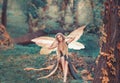 Charming fairy woke up in forest, sweetly smacks after sleeping, cue girl with blond hair, eyes closed in long green Royalty Free Stock Photo