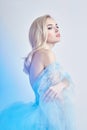 Charming fairy woman in a blue cotton dress and long hair, mysterious, delicate blonde girl with perfect skin and makeup
