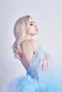 Charming fairy woman in a blue cotton dress and long hair, mysterious, delicate blonde girl with perfect skin and makeup