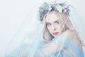 Charming fairy woman in a blue ethereal dress and a wreath on her head on white background, gentle mysterious blonde girl Royalty Free Stock Photo