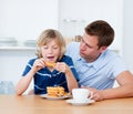 Charming father and his son eating waffles Royalty Free Stock Photo