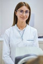 Charming female doctor standing by autorefractor in clinic Royalty Free Stock Photo