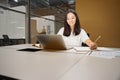 Charming female entrepreneur working online while using internet in the office Royalty Free Stock Photo