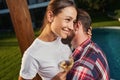 Charming female holding glass with beverage and hugging man in th outdoors Royalty Free Stock Photo