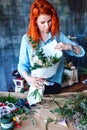 Charming cheerful female shop assistant making bouquet with purple crocus, Eucalyptus poplaraceous populus and Chrysanthemum singl Royalty Free Stock Photo