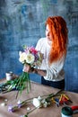 Charming cheerful female shop assistant making bouquet with purple crocus, Eucalyptus poplaraceous populus and Chrysanthemum singl Royalty Free Stock Photo