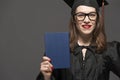 Charming female student smiling in eyeglasses wearing black mantle