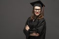 Charming female student smiling in eyeglasses wearing black mantle