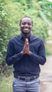 A charming, friendly african man who stands smiling and shows sincere respect Royalty Free Stock Photo