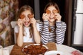 Charming, funny and laughing girls hold heart-shaped cookies, close their eyes and fool around. Valentine`s Day and Women`s Day