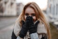 Charming funny young woman with beautiful eyes laughs and covers her face with her hands. Cheerful stylish girl. Royalty Free Stock Photo