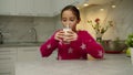 Charming girl drinking milk, relishing freshness of dairy at home