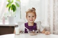 Charming girl eats cereal with milk for Breakfast and . On the table are chocolate flakes, a glass of milk. Healthy Royalty Free Stock Photo