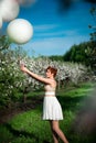 Charming girl holding white balloons looking sadly at them Royalty Free Stock Photo