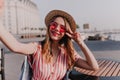 Charming girl in pink sunglasses having fun in city and making selfie. Wonderful blonde young woman Royalty Free Stock Photo