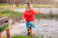 Charming girl running in big puddle Royalty Free Stock Photo