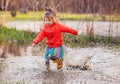 Charming girl running in big puddle Royalty Free Stock Photo