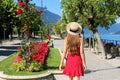 Charming girl walking along Lake Como on flowered street of Bellagio, Italy