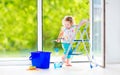 Charming girl washing a window in white room Royalty Free Stock Photo