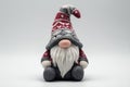 Cute handmade gnome doll wearing a red and gray knitted hat with intricate patterns and a long white beard Generative AI Royalty Free Stock Photo