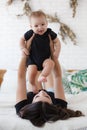 Charming happy little baby boy having fun with mom brunette woman on bed in the bright bedroom Royalty Free Stock Photo