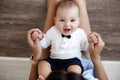 Charming happy little baby boy having fun with mom brunette woman on bed in the bright bedroom Royalty Free Stock Photo