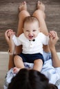 Charming happy little baby boy having fun with mom brunette woman on bed in the bright bedroom Royalty Free Stock Photo