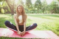 Gorgeous athletic woman doing yoga at the park