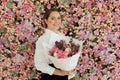 Charming healthy woman smiling and holding colorful pink color flower bouquet on floral spring or summer background, studio Royalty Free Stock Photo